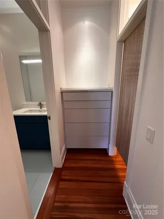 a view of a hallway with wooden floor and stairs