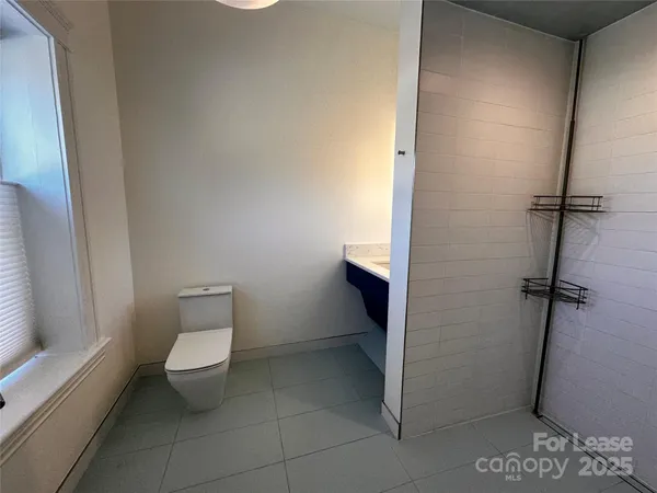a bathroom with a toilet and a shower