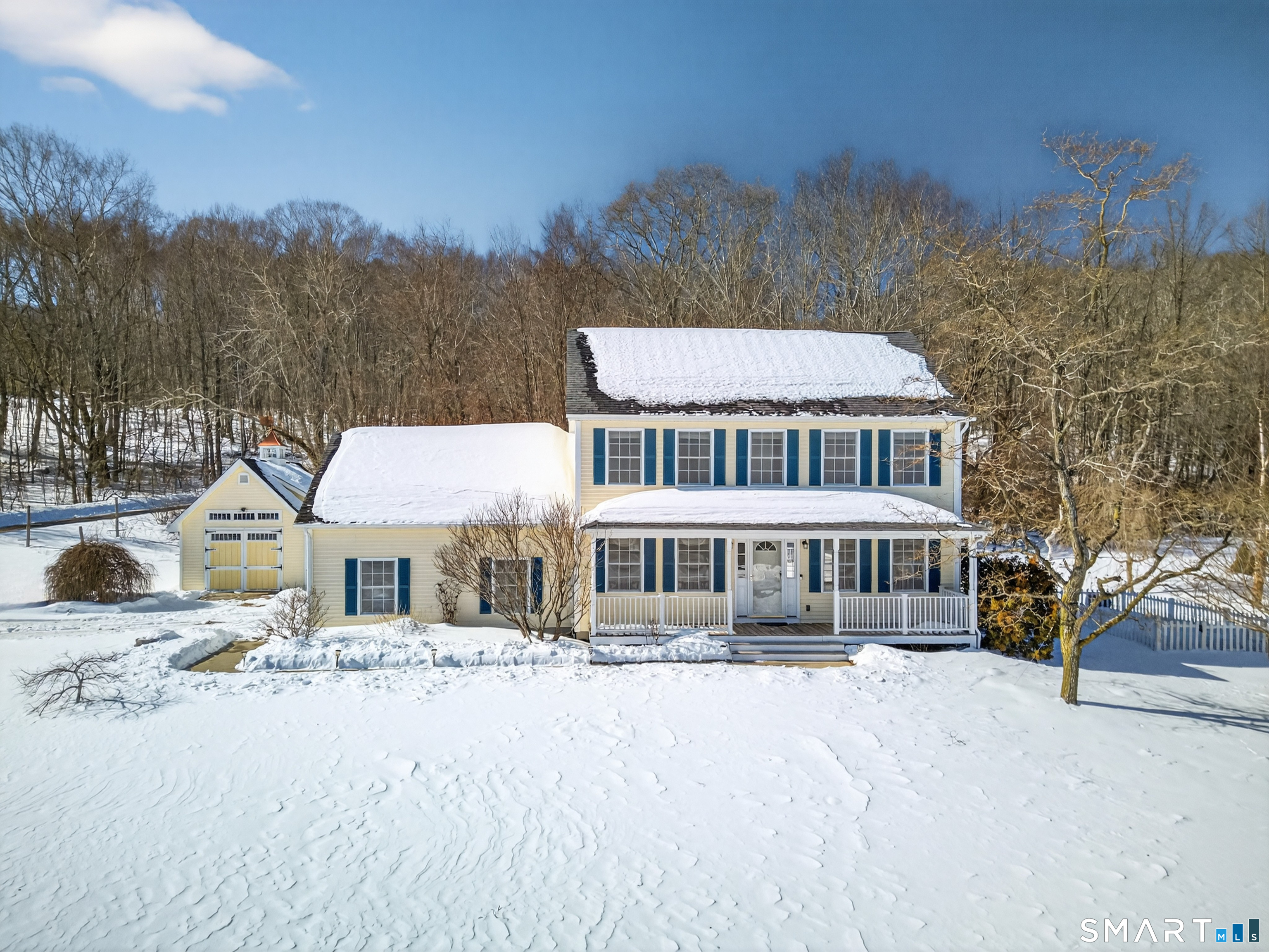 a front view of a house with a yard and covered with snow