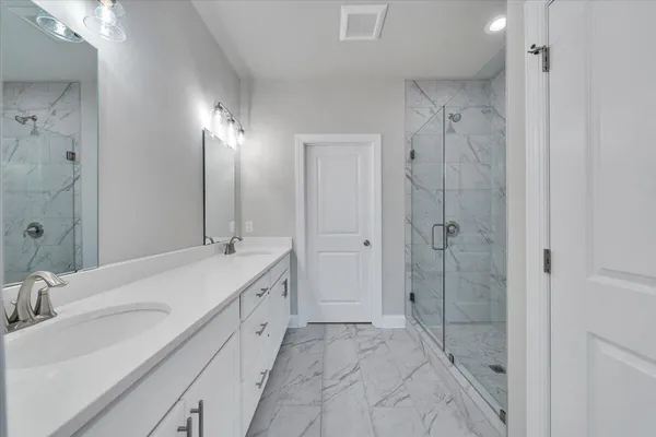 a spacious bathroom with a shower sink and mirror