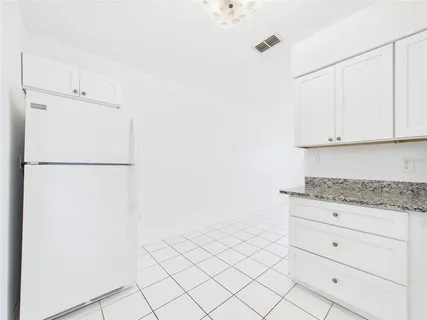 a kitchen with white cabinets and white appliances