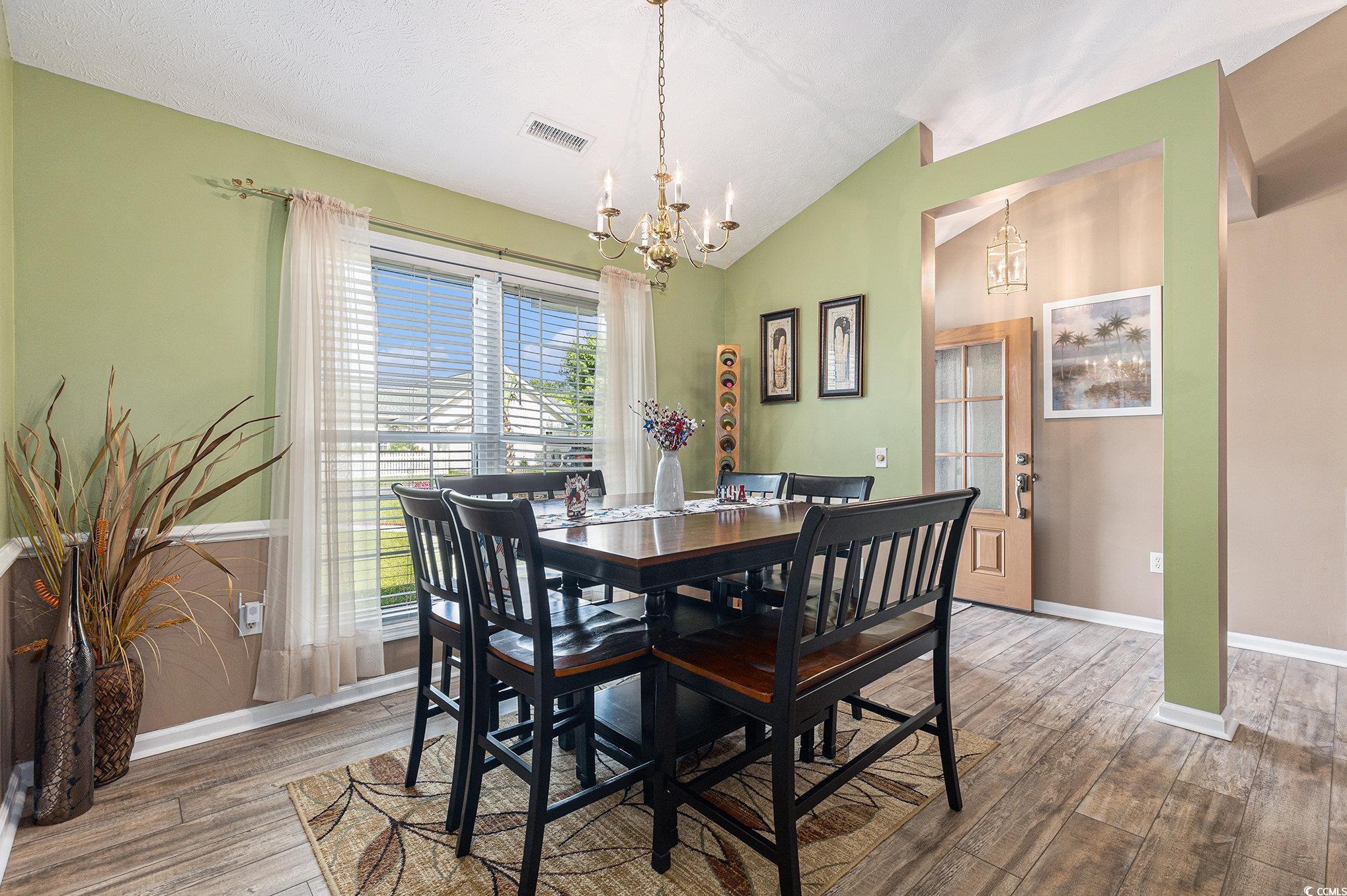 1105 Lampwick Lane Murrells Inlet, SC 29576 - Photo 10 of 40 Dining space featuring a chandelier, wood finished floors, baseboards, and lofted ceiling