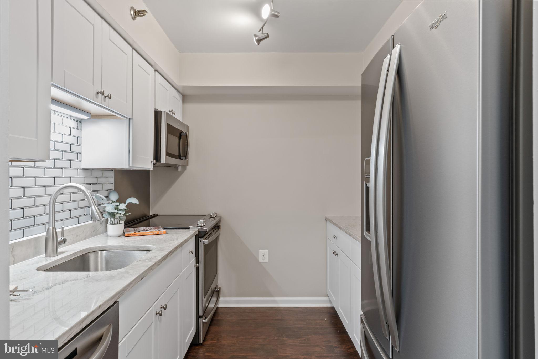 1301 North Courthouse Road, Unit 914 Arlington, VA 22201 - Photo 13 of 50 a kitchen with stainless steel appliances granite countertop a refrigerator a sink and white cabinets