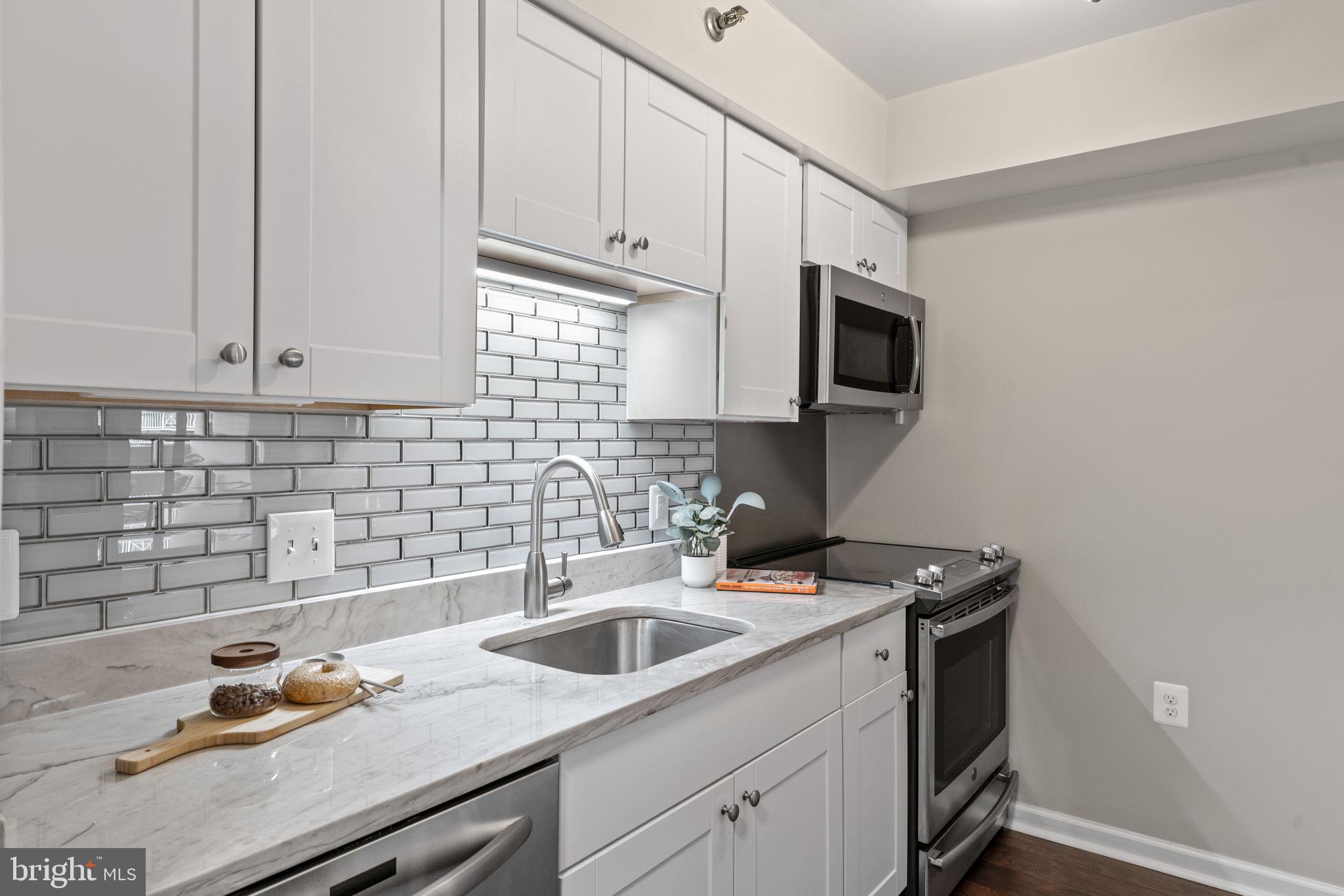 1301 North Courthouse Road, Unit 914 Arlington, VA 22201 - Photo 14 of 50 a kitchen with stainless steel appliances granite countertop a sink stove and microwave