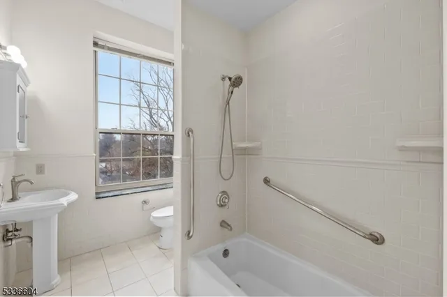 a bathroom with a granite countertop sink a toilet and shower