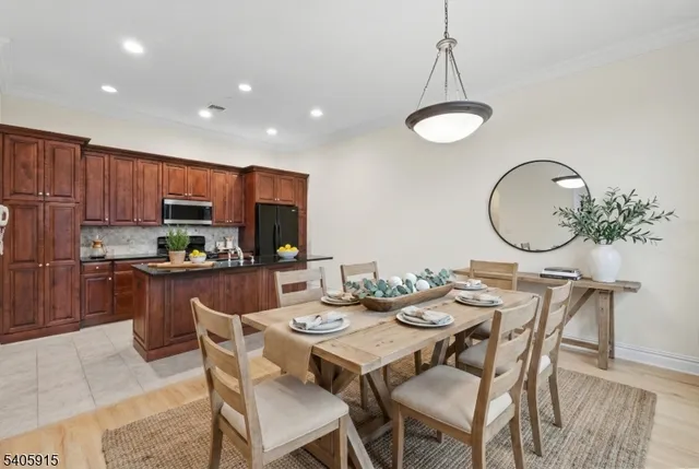 a dining room with stainless steel appliances a dining table and chairs