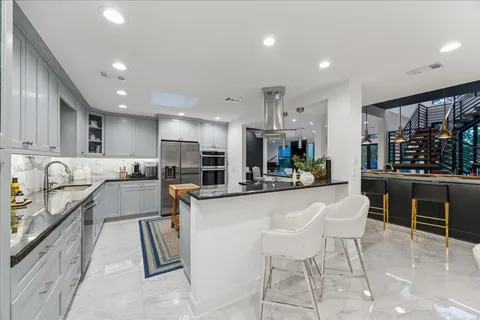 a kitchen with stainless steel appliances kitchen island granite countertop a sink and a stove