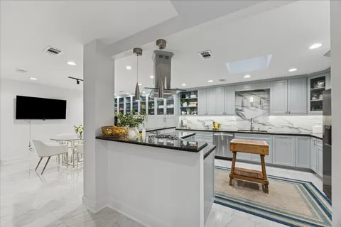 a dining room with stainless steel appliances kitchen island granite countertop a dining table chairs and view kitchen