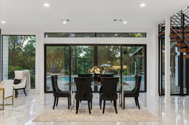 a dining room with furniture floor to ceiling windows and view