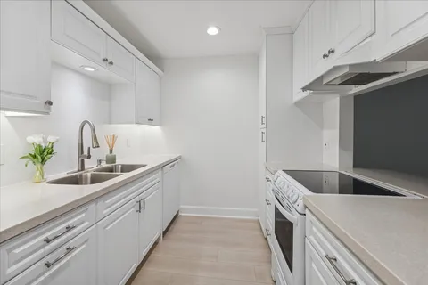 a view of a patio with table and chairs potted plants with wooden floor and fence