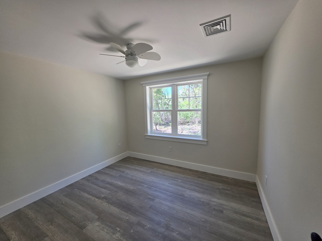 87 Acapesket Road, Unit 2A Falmouth, MA 02536 - Photo 8 of 17 an empty room with wooden floor ceiling fan and windows