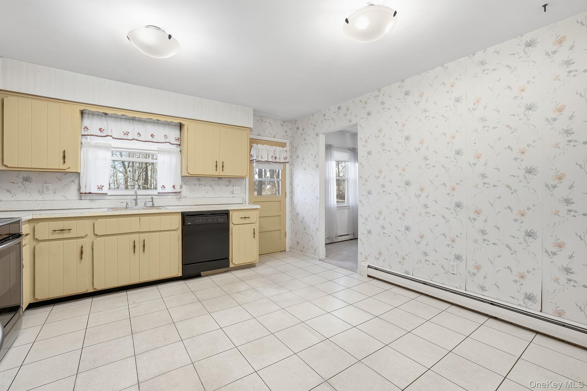42 Bayberry Hill Road Mahopac, NY 10541 - Photo 13 of 49 Kitchen featuring light countertops, wallpapered walls, dishwasher, stainless steel range oven, and a baseboard radiator