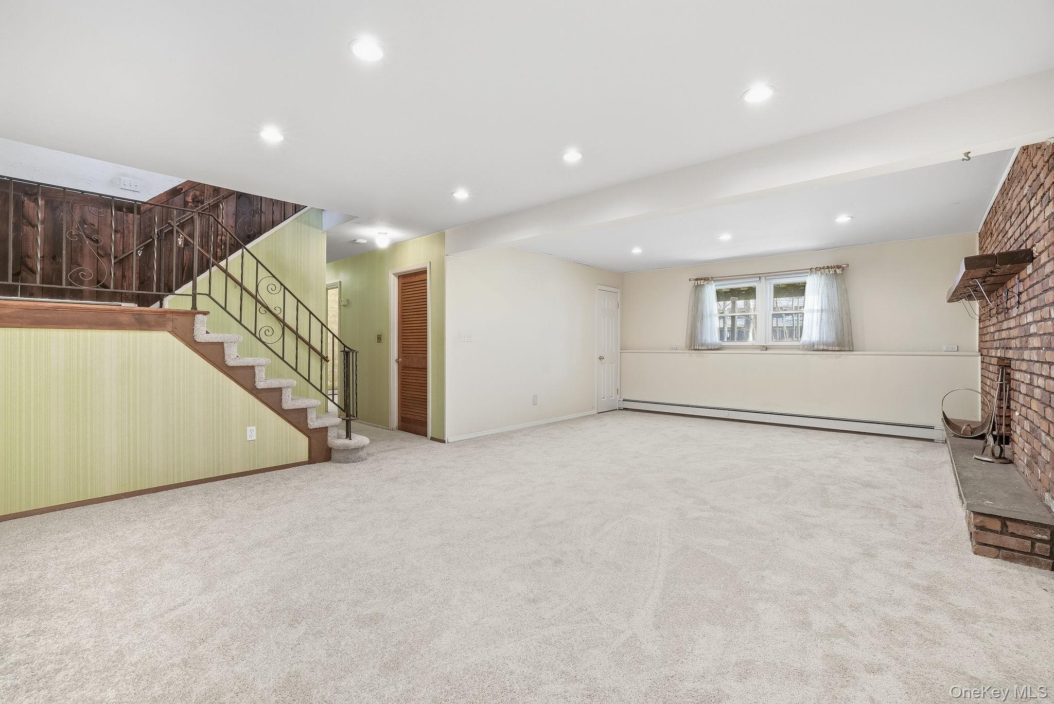42 Bayberry Hill Road Mahopac, NY 10541 - Photo 23 of 49 Below grade area with stairway, a baseboard radiator, carpet floors, and recessed lighting