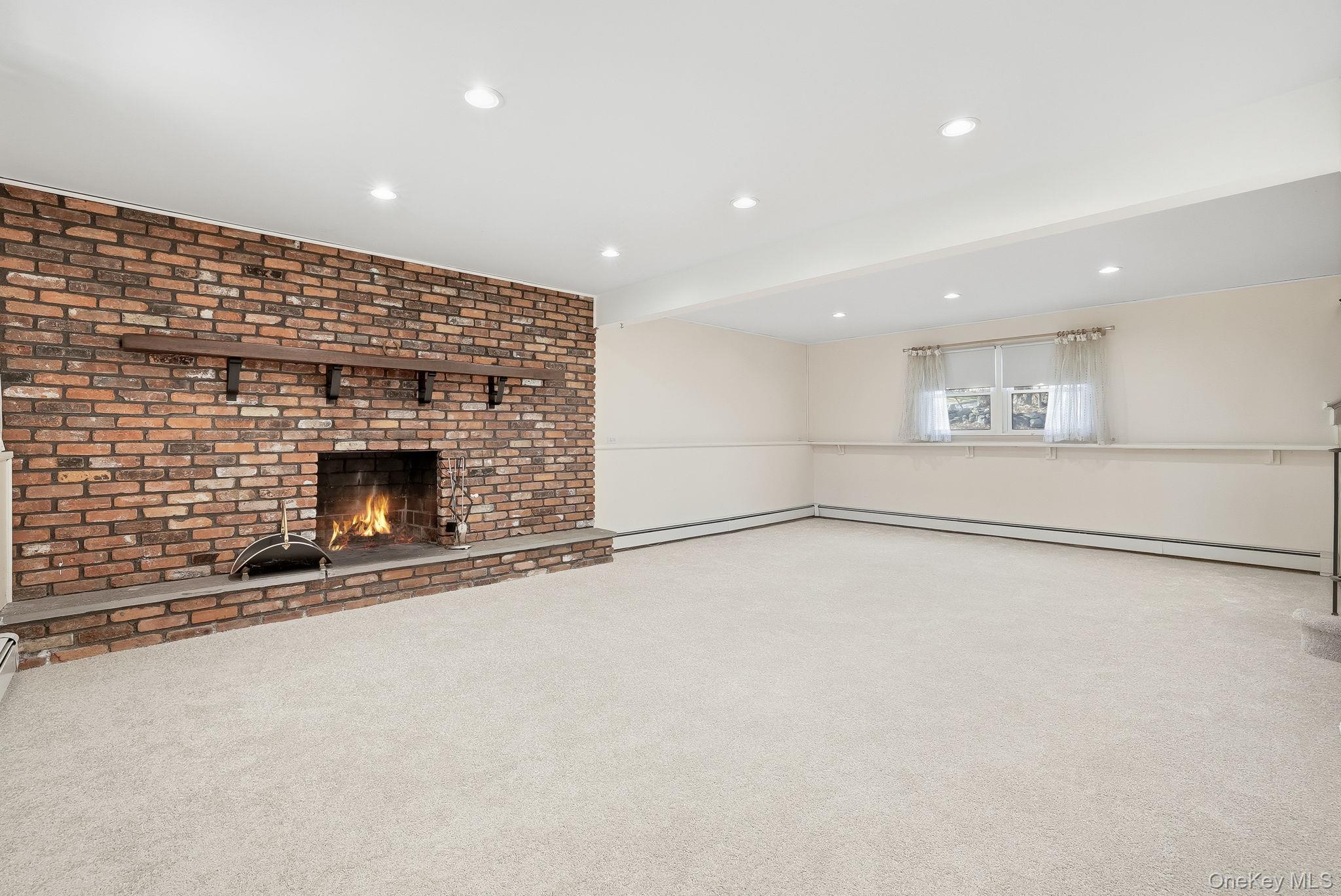 42 Bayberry Hill Road Mahopac, NY 10541 - Photo 24 of 49 Unfurnished living room with carpet flooring, a fireplace, recessed lighting, and a baseboard radiator