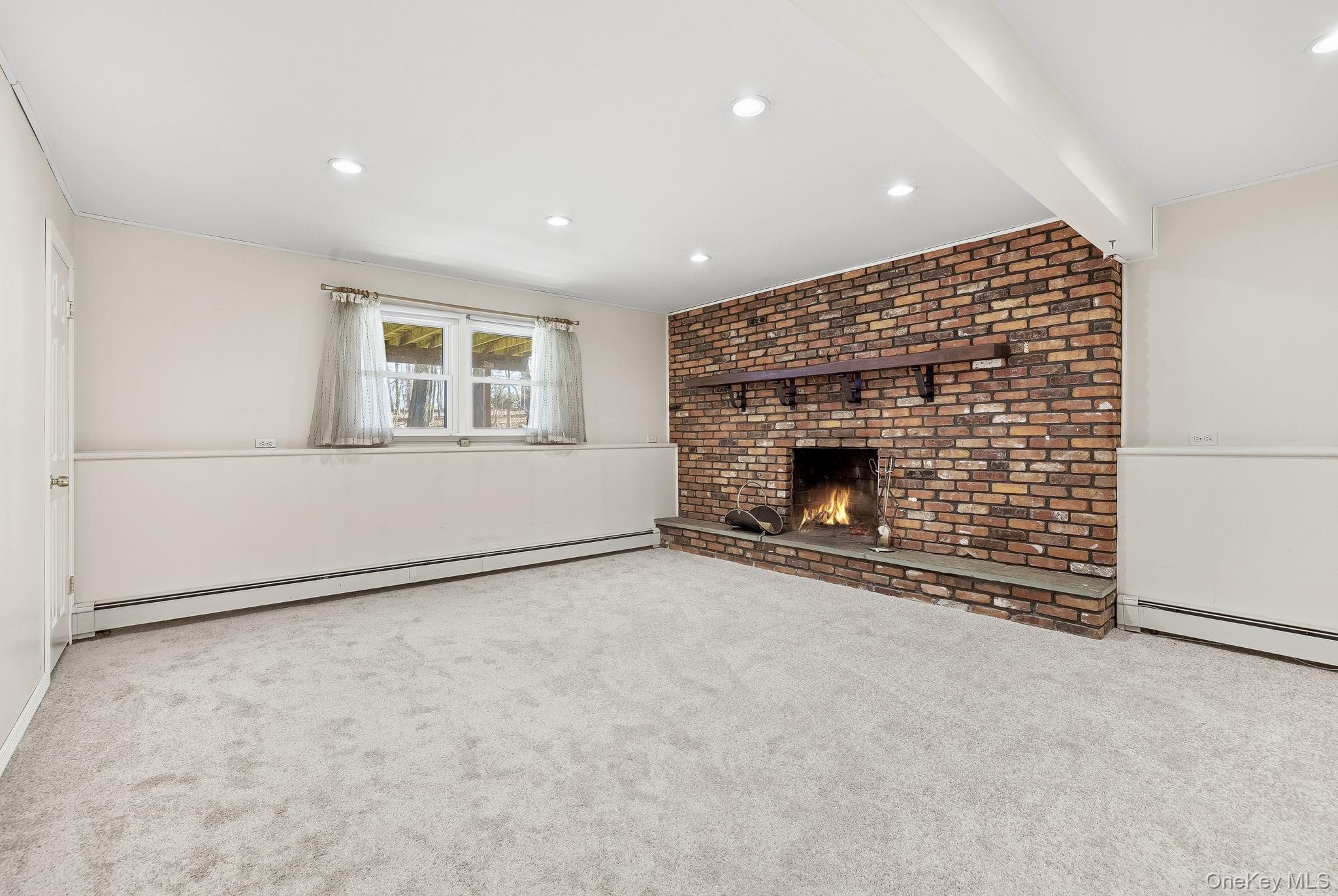 42 Bayberry Hill Road Mahopac, NY 10541 - Photo 25 of 49 Unfurnished living room with light colored carpet, a baseboard radiator, recessed lighting, and a fireplace