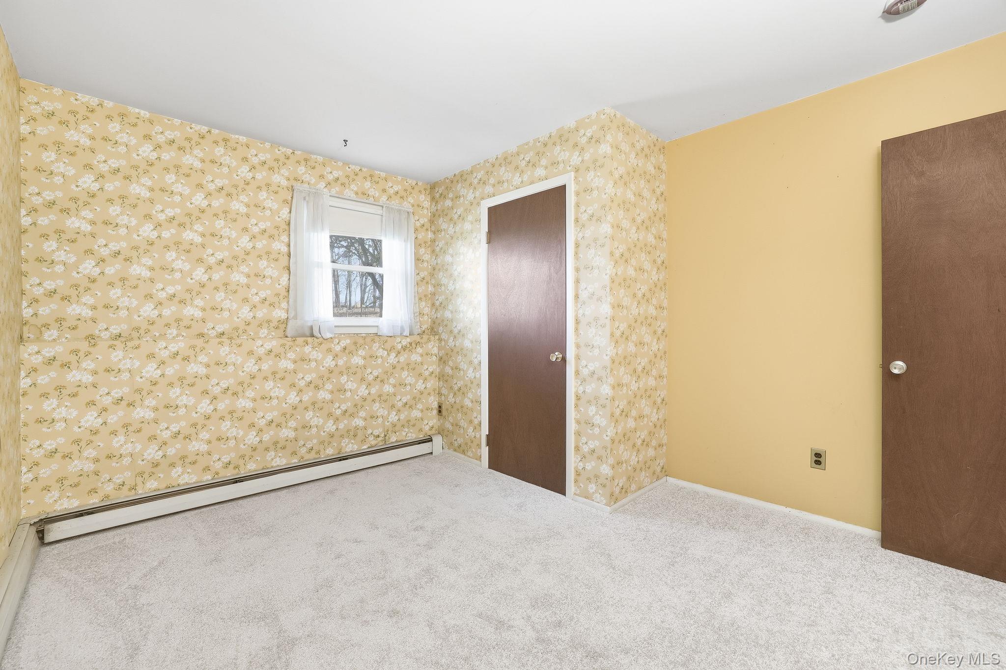 42 Bayberry Hill Road Mahopac, NY 10541 - Photo 26 of 49 Unfurnished bedroom featuring baseboard heating, carpet floors, wallpapered walls, and a baseboard radiator