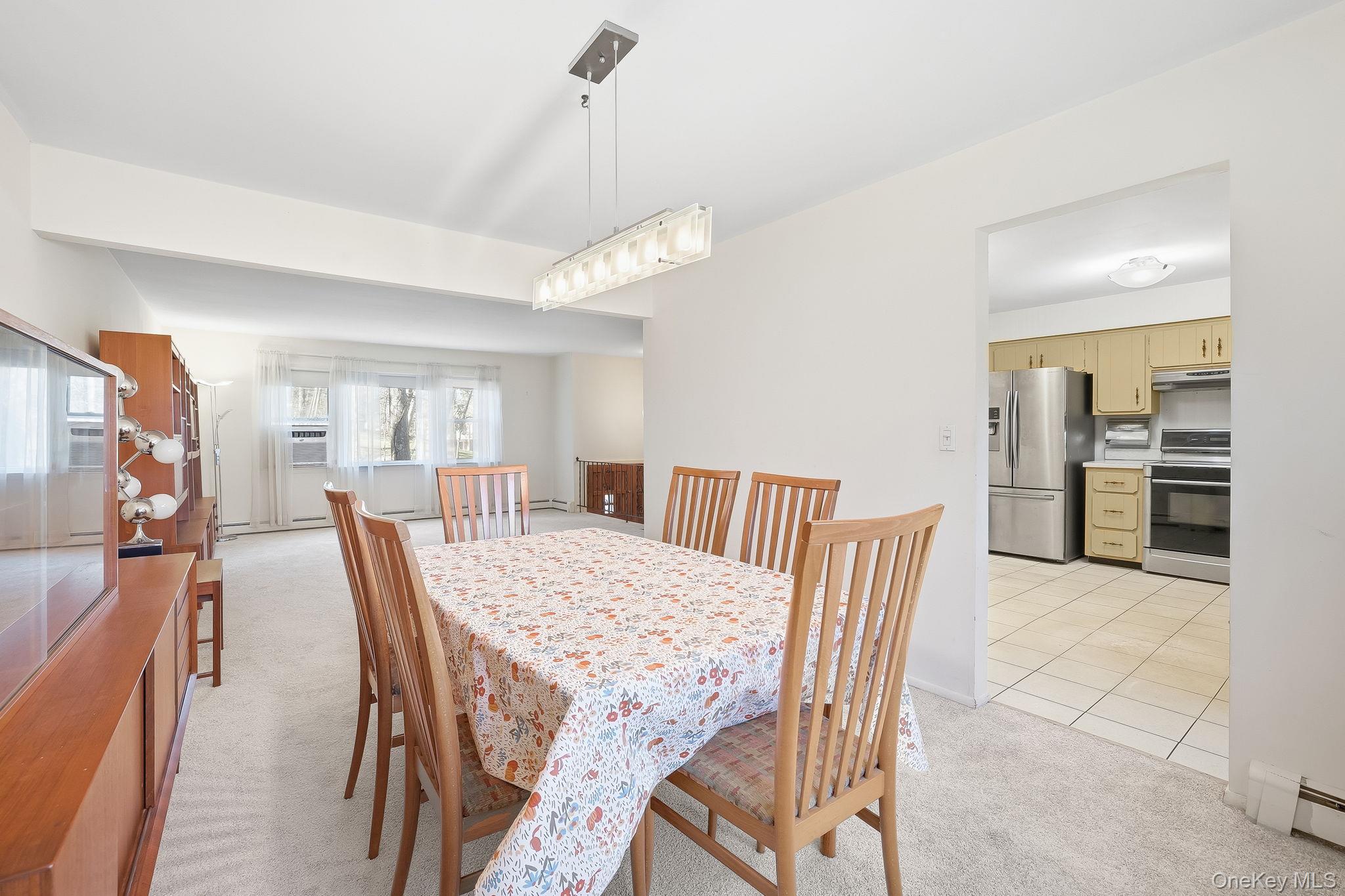 42 Bayberry Hill Road Mahopac, NY 10541 - Photo 9 of 49 Dining area with light carpet, a baseboard heating unit, and light tile patterned floors