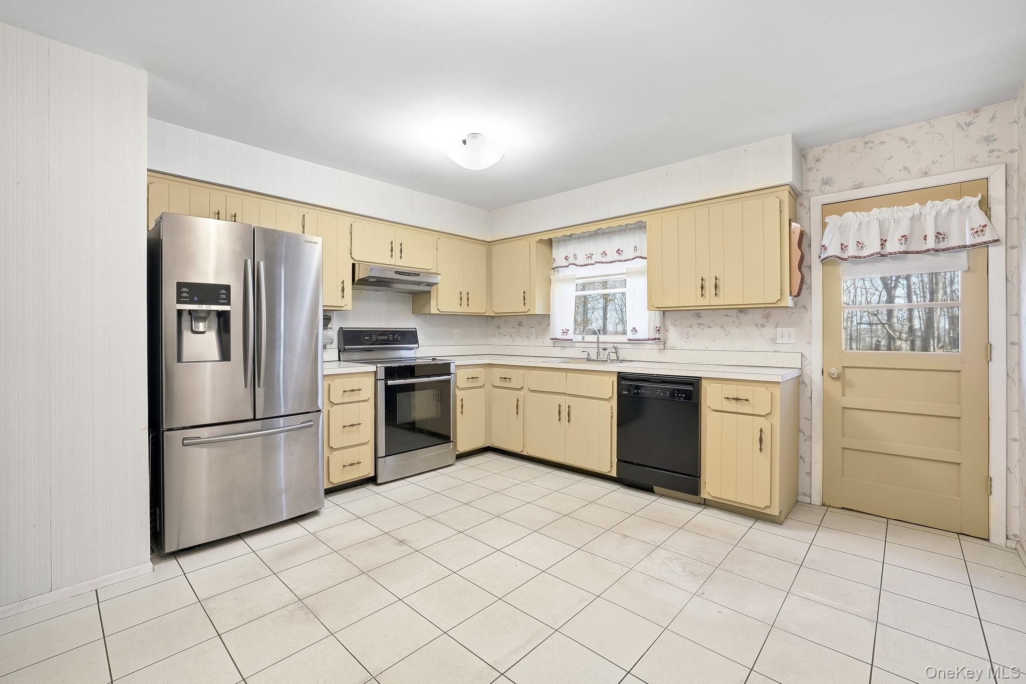 42 Bayberry Hill Road Mahopac, NY 10541 - Photo 10 of 49 Kitchen with light countertops, appliances with stainless steel finishes, under cabinet range hood, and light tile patterned floors