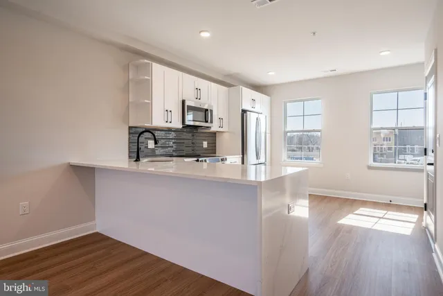 a view of kitchen with wooden floor and electronic appliances