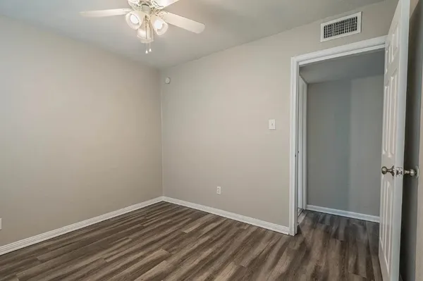 a view of an empty room with wooden floor
