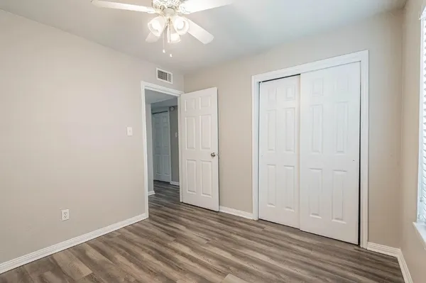 an empty room with a window and a fan