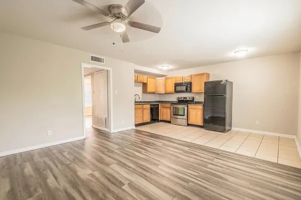 a kitchen with stainless steel appliances kitchen island granite countertop a stove a refrigerator and cabinets