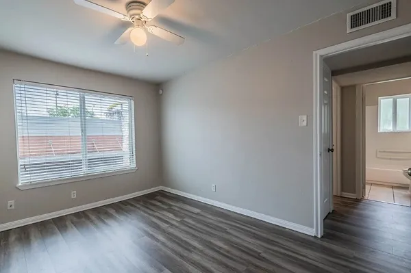 a view of an empty room with wooden floor