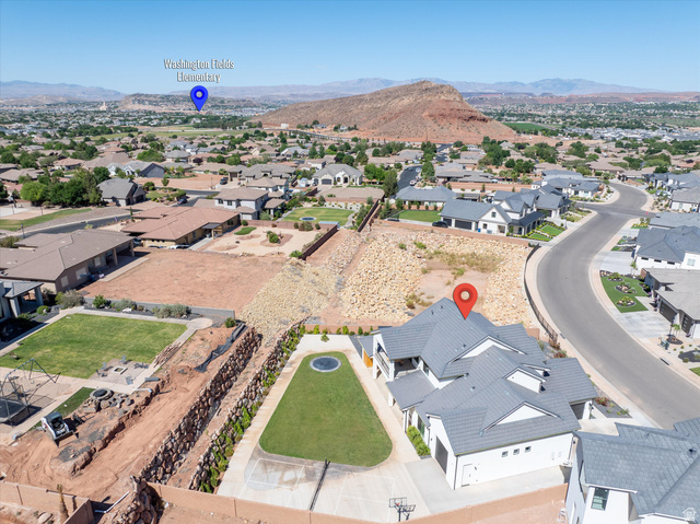 1192 East Corral Way Washington, UT 84780 - Photo 76 of 81 Aerial perspective showcasing a residential neighborhood with surrounding desert landscape and distant mountains