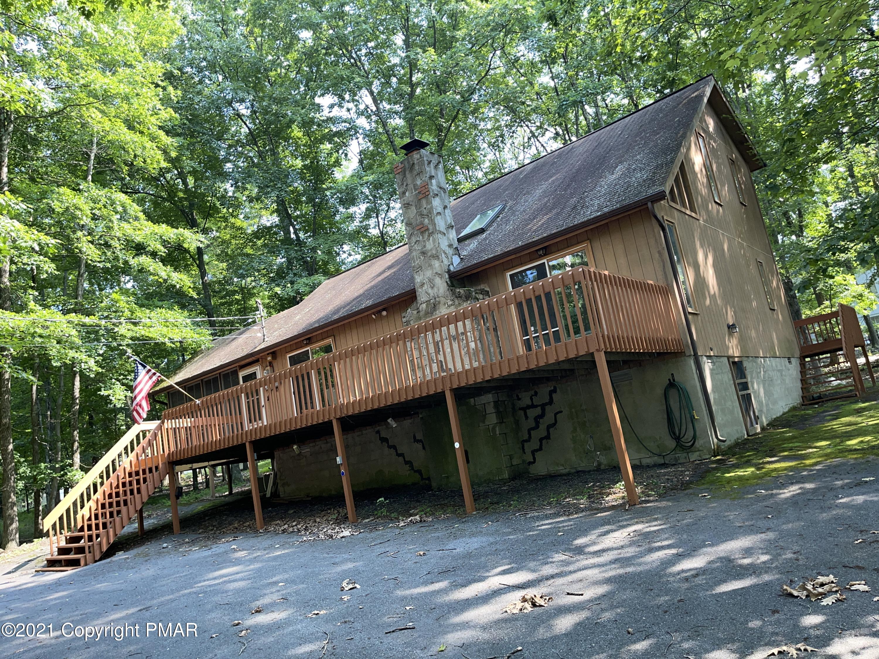 a view of a house with a yard balcony and wooden fence
