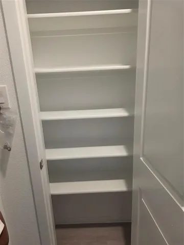 a view of walk in closet with empty racks
