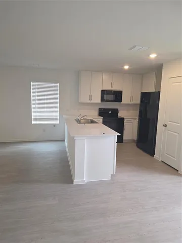 a view of kitchen with refrigerator and window