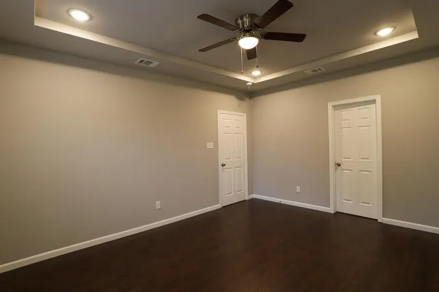 an empty room with a ceiling fan and a window