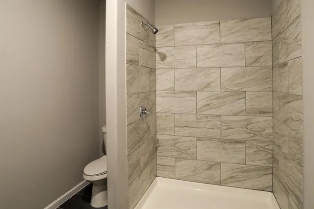 a bathroom with a toilet and shower