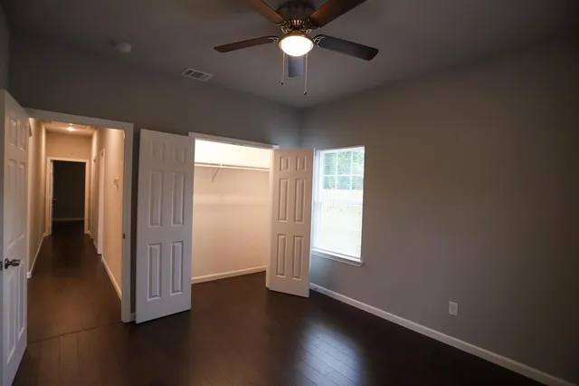 a view of empty room with wooden floor