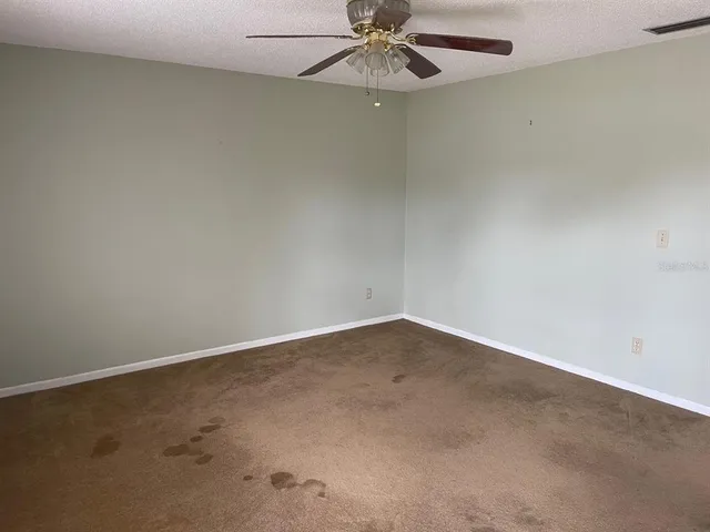 an empty room with a fan and a window