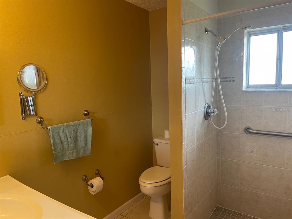 3048 Unity Tree Drive Edgewater, FL 32141 - Photo 7 of 9 a bathroom with a toilet and a shower
