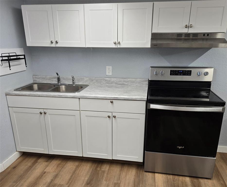 121 Arrowhead Quitman, TX 75783 - Photo 8 of 14 a kitchen with granite countertop white cabinets and a stove