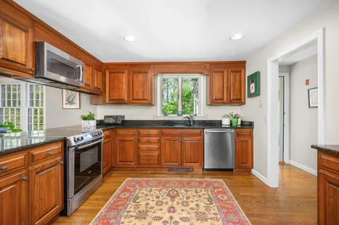 a kitchen with stainless steel appliances granite countertop a stove a sink and a refrigerator