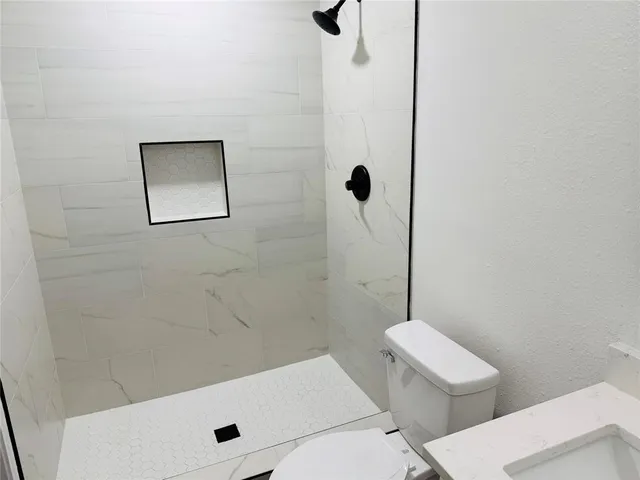 a bathroom with a toilet a sink and shower