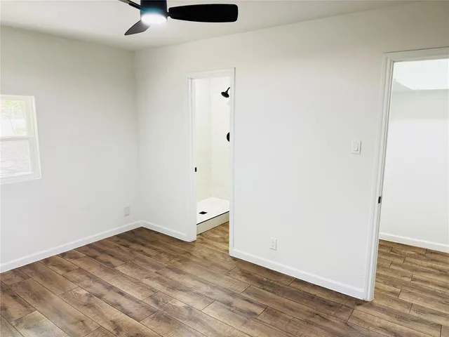 a view of empty room with wooden floor