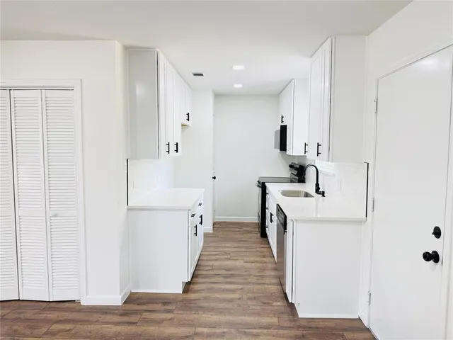 a kitchen with white cabinets and stainless steel appliances