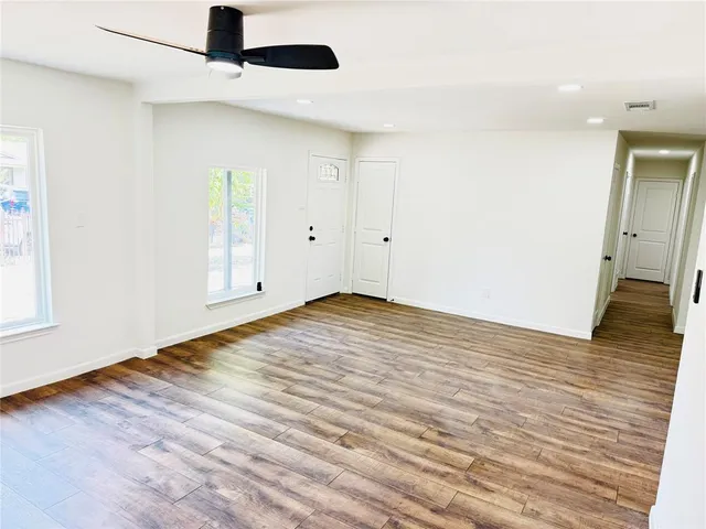 a view of empty room with wooden floor