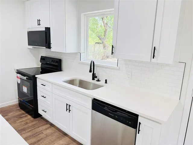 a kitchen with a sink and a stove top oven