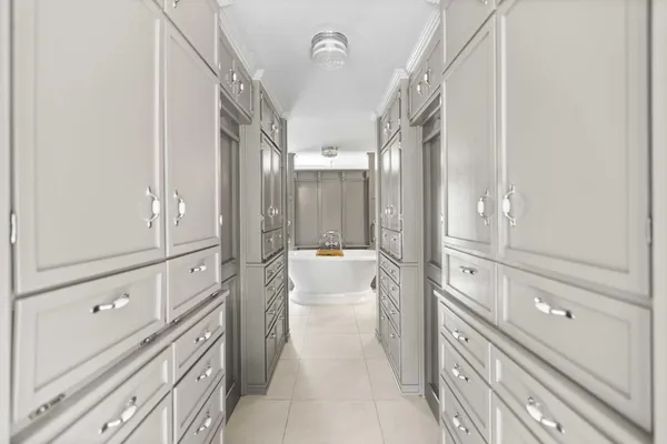 a view of a hallway with closet and mirror