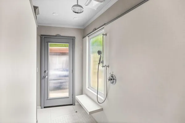 a bathroom with a glass shower door and a window