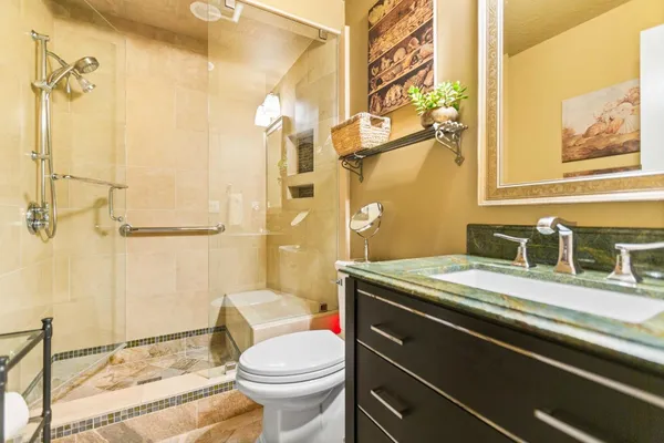 a bathroom with a granite countertop sink mirror vanity and toilet