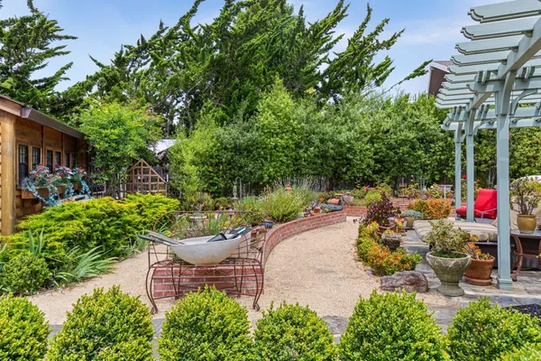 a patio with table and chairs and potted plants