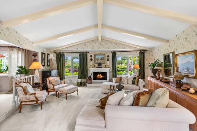 a living room with furniture a fireplace and a large window