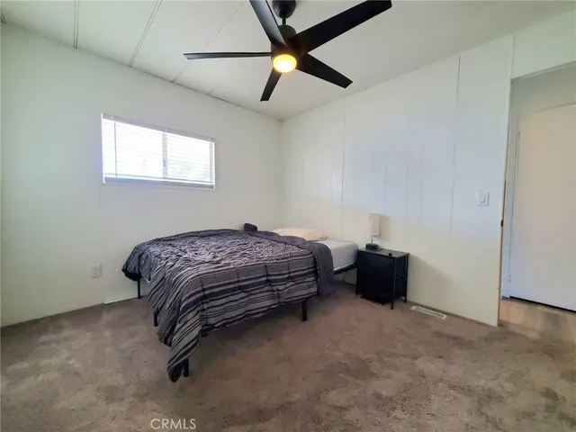 a bedroom with a bed and a ceiling fan