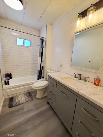 a bathroom with a granite countertop toilet sink and mirror